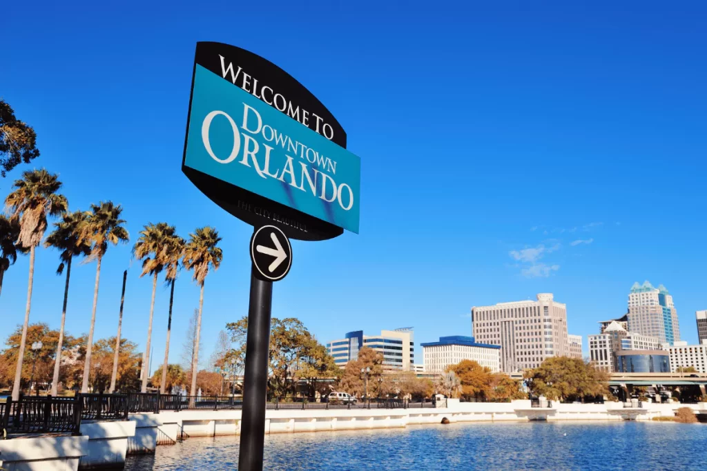 Welcome sign to Downtown Orlando with skyline view.