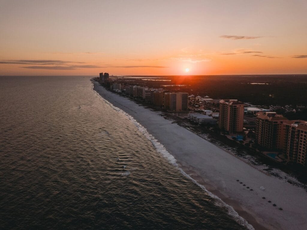 Sunset over beach and city skyline